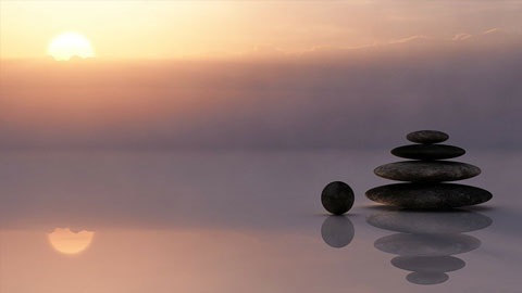 pile of stones on water before a peaceful sunset