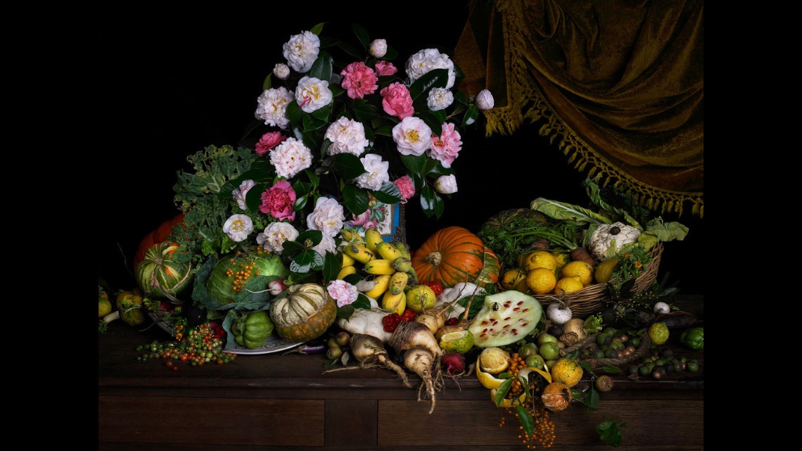 Photograph of flowers and fruit on a table