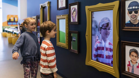 Children in front of potrait pieces from the activity