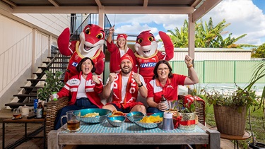 City of Moreton Bay locals dressed in Dolphins fan gear cheering on their team with mascots Phinny and Sandy.