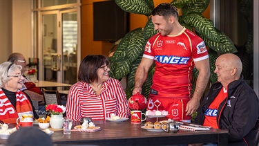 Sean O’Sullivan pouring a cup of tea with fans and retirees.