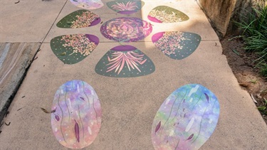 Circular vinyl artwork featuring leafy botanical patterns installed on concrete.