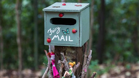 a light green letterbox with fairy toys and stickers to decorate it