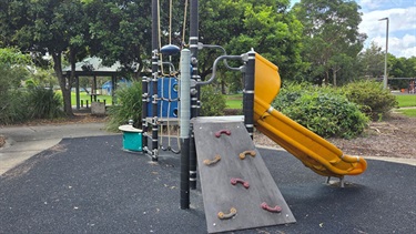 Playground with adventure fort, yellow slide on soft fall matting