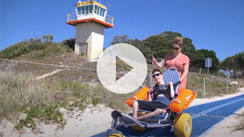 Boy on wheelchair goes to beach