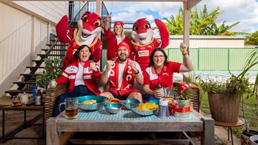 City of Moreton Bay locals dressed in Dolphins fan gear cheering on their team with mascots Phinny and Sandy.