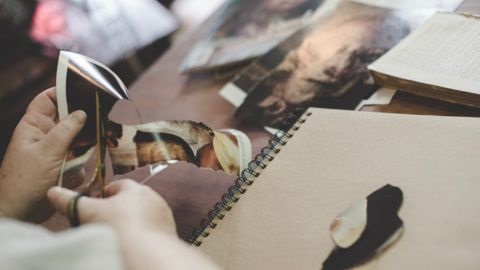 Person cutting our pictures and scrapbooking