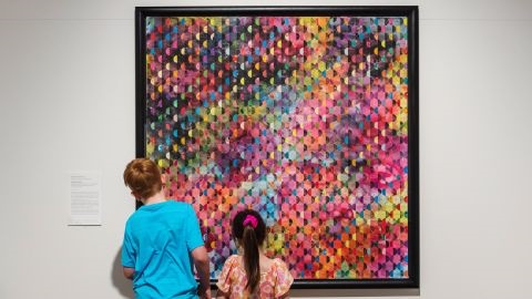 Two kids looking at multi-coloured abstract artwork
