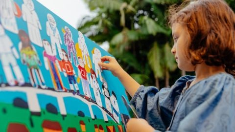 Kid looking at coloured painting