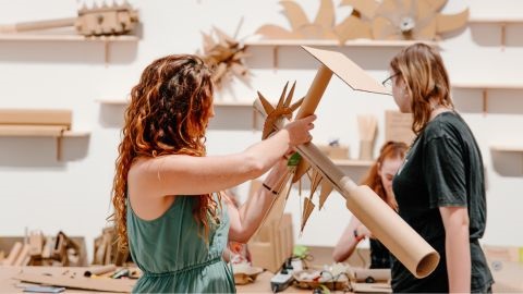 People creating a sculpture with wood materials