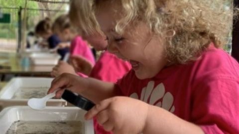 Curly-haired girl with water container