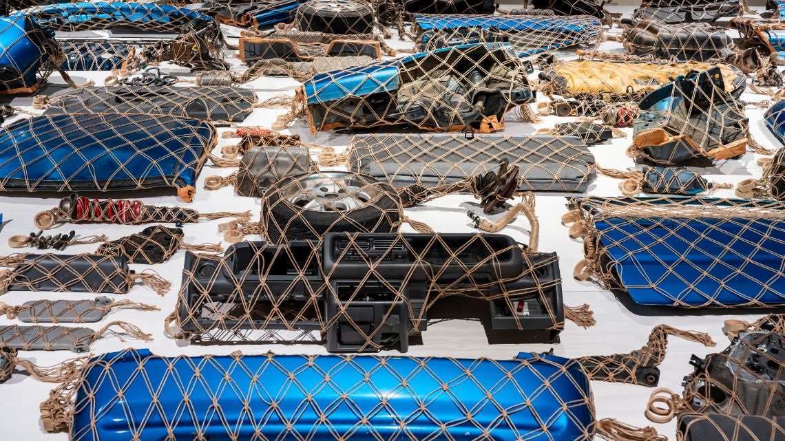 Man-made items wrapped in netting on display