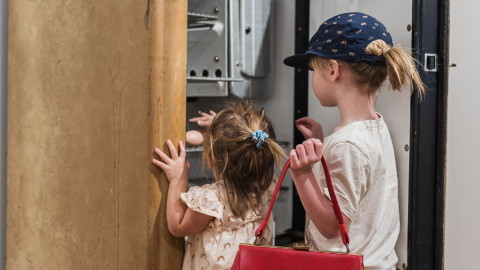 two children finding an egg in a cabinet