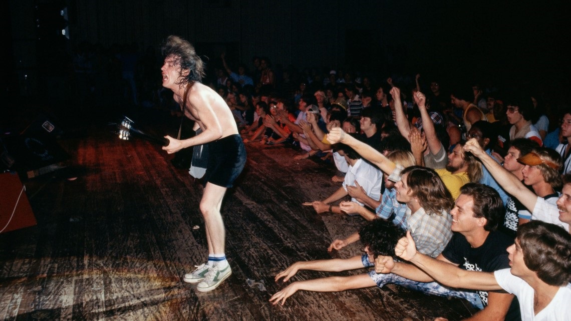 Man in stage playing guitar to an audience