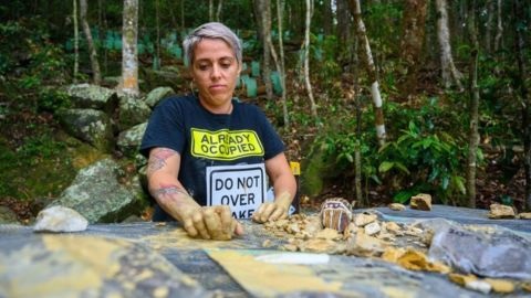 Woman in forest creating mural