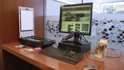 Desk set up with computer and scanner ready for assisting history enquiries