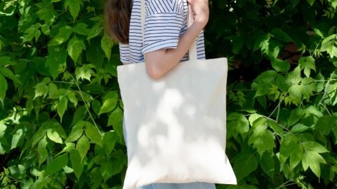 Woman carrying white tote bag