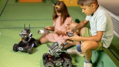 A boy and girl playing with robotic cars
