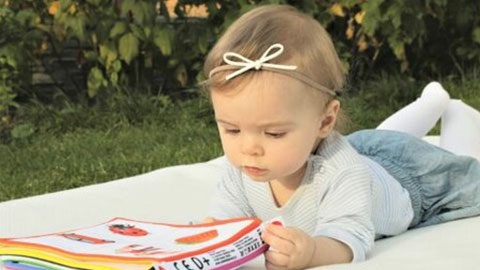 Baby playing with book on play mat