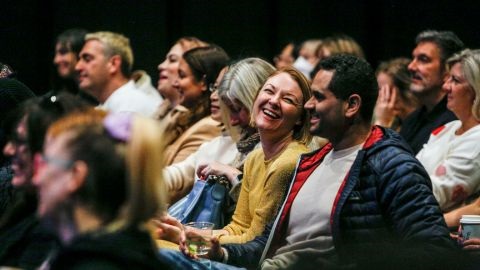 People laughing in theatre seating
