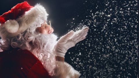 Santa Claus blowing snow flakes