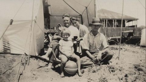 Historic photo of a family sitting on the beach