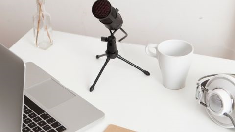 Microphone and laptop on white desk
