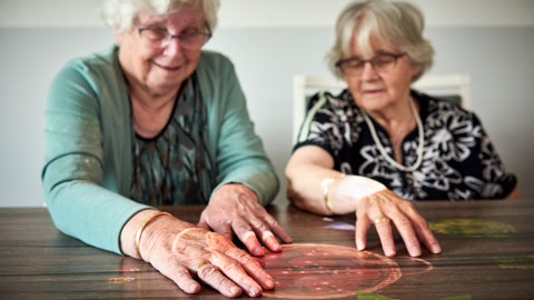 Two women playing a gardening game on the magic table