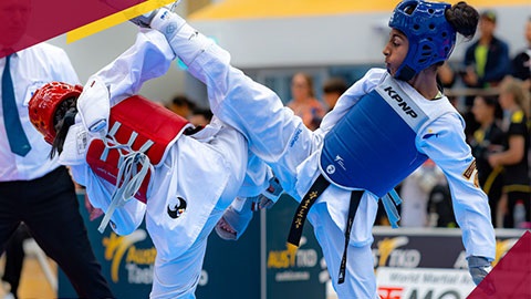 Two taekwondo competitors competing with protective gear on.