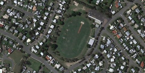 An aerial view of Zammit Oval, a grass oval surrounded by trees and houses in neighboring streets.