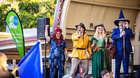 4 poeople on a park stage dressed in fantasy clothing. 