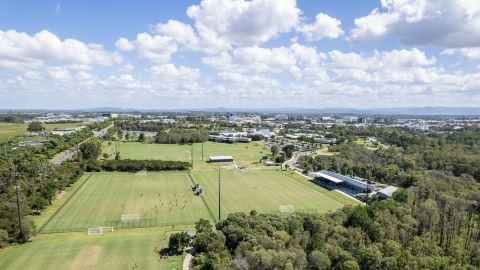 Aerial shot of sporting field and buildings seen in background