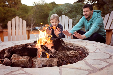 Two people around a fire pit