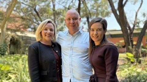 From left - Deputy Mayor Councillor Jodie Shipway (Division 4), Steve Zmuda and Councillor Brooke Savige (Division 1) standing in a garden with their arms around each other.
