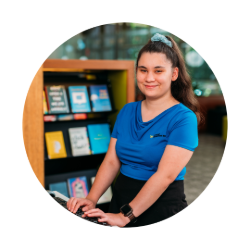 Cassie Gibson smiling in a library typing on a keyboard