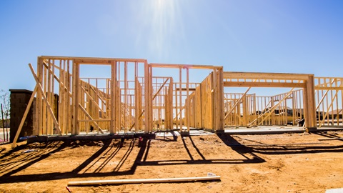 A house under construction, currently with framing.