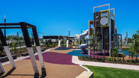 Image of the Mill Adventure Playground including the colourful climbing structure and flying fox area .
