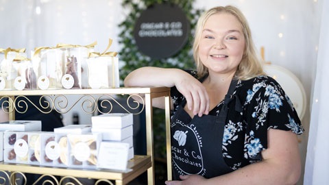 Business owner standing in front of her stall selling chocolates