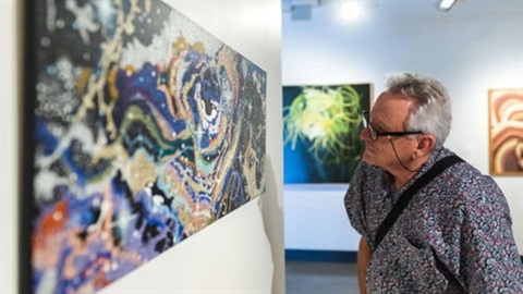 Man looking at artwork on wall