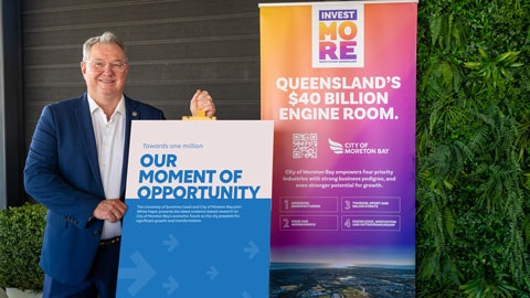 Mayor Peter Flannery standing next to two signs, one for the white paper, one for Invest Moreton Bay.