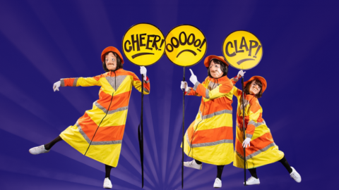 Three female characters dressed as lollipop ladies carrying reactive signs