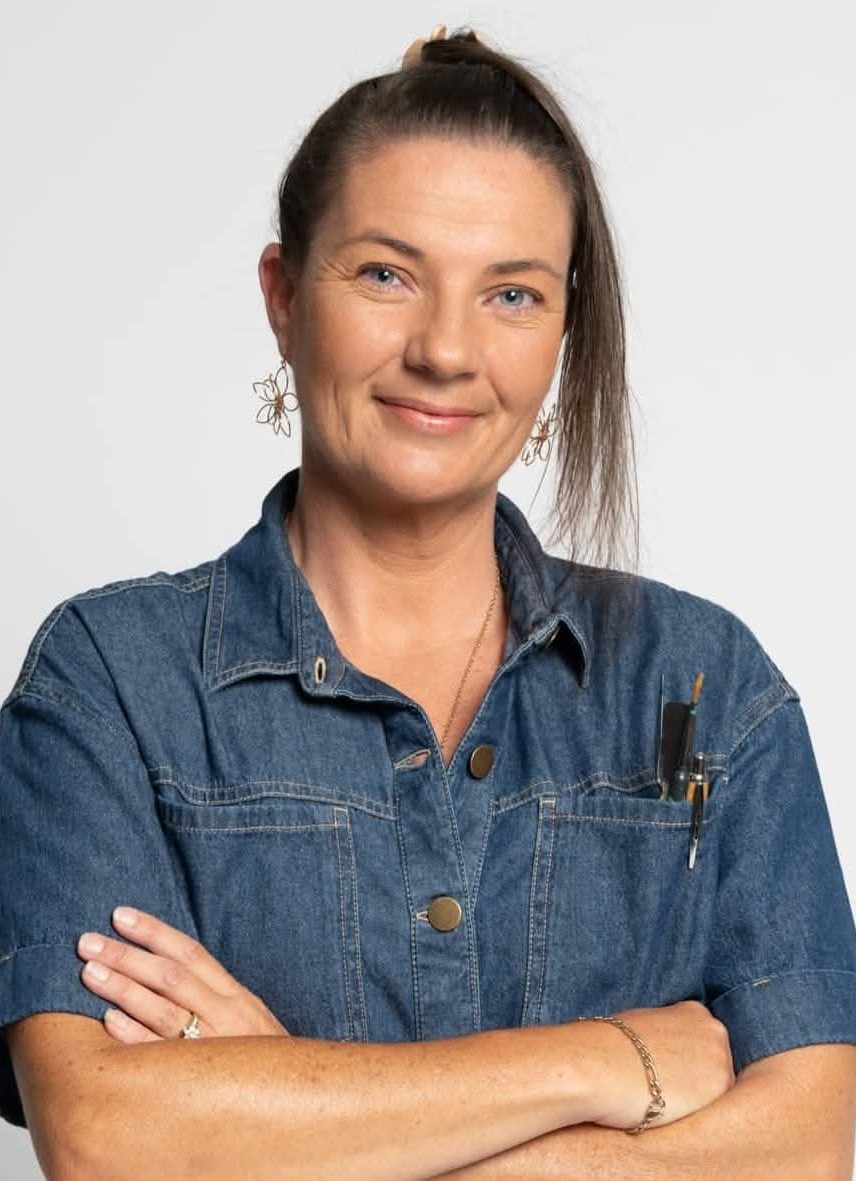 Natalie Lord, a white femaile in a denim shirt wearing a pony tail and dangling earring.
