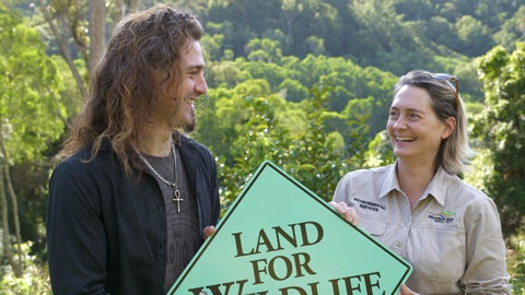 A person being given a land for wildlife sign by a Council ranger