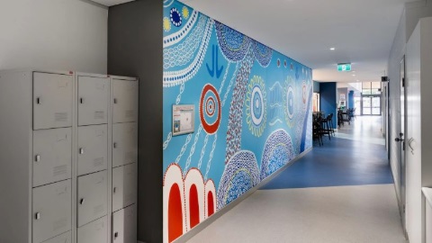 a mural painting on a large wall with blue red green and white colours forming a beautiful piece