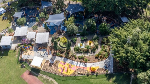 an ariel shot of the all abilities playground displaying play equipment, trees, and structures